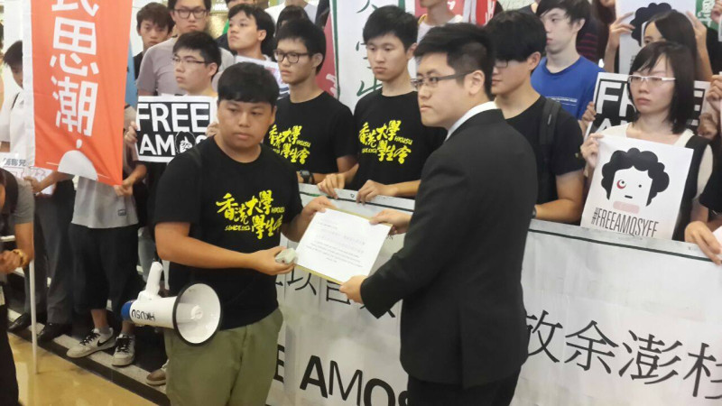 港大學生會代表李峰琦(左)於今日抗議現場，向新加坡駐港副領事(右)遞交靠抗議書。圖:翻攝香港大學學生會校園電視臉書   