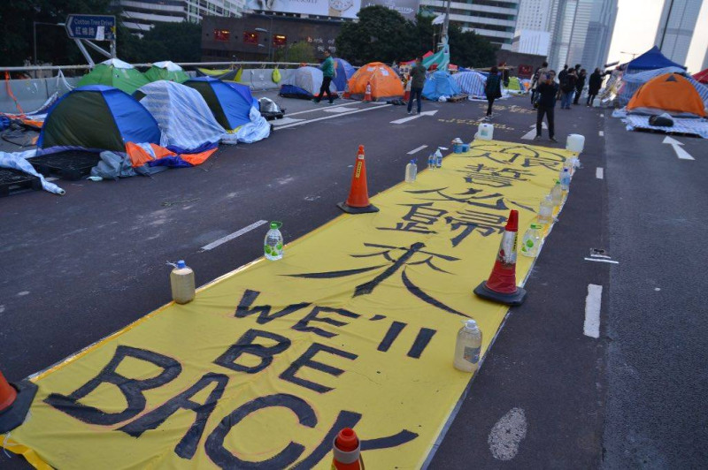 港警11日將針對佔中進行最後清場，有民眾在佔領區自製大型標語並寫上「人民誓必歸來，WE’ll BE BACK」。圖：翻攝自香港獨立媒體網臉書   