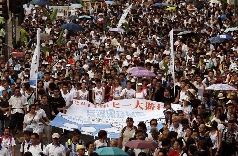 香港特首梁振英15日將向人大常委會提交政改報告，並提出修改特首選舉辦法；另外，報告中也將反映「佔中」全民投票結果及七一遊行人士訴求。圖為七一遊行。圖片來源：達志影像/路透社資料照片   