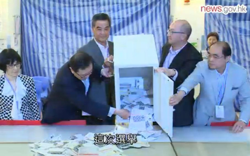 香港22日舉行區議會選舉，投票人數及投票率都創下新高紀錄，香港特首梁振英（中）參與打開票匭的記者會。圖：翻攝香港政府新聞處   