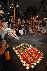 環保團體12日晚間在立法院大門口，舉辦反核、刪除核四預算守夜活動，環保人士文魯彬（前左）與向日葵廢核行動聯盟成員，點燭光將守夜至13日。圖片來源：中央社   