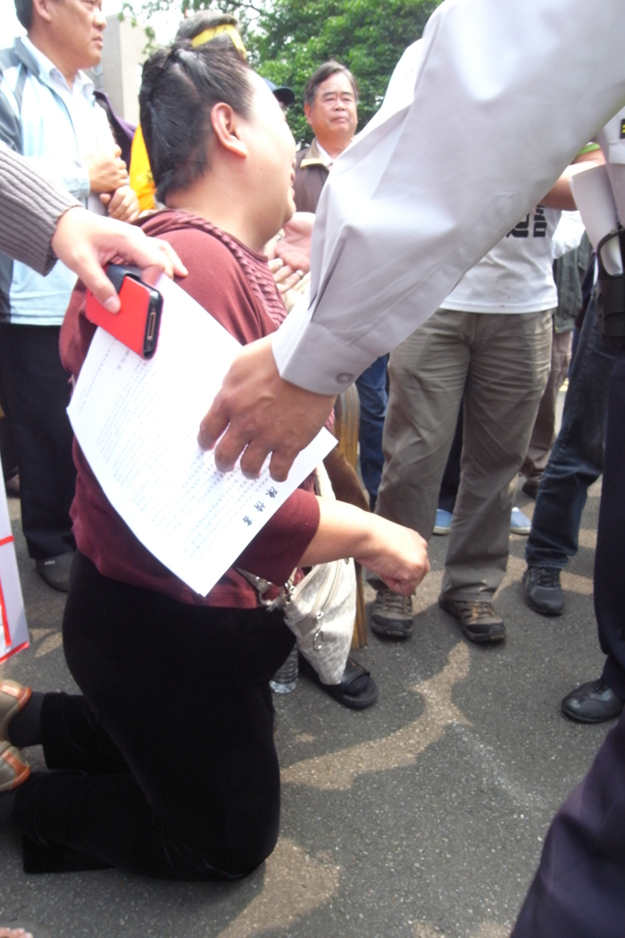 一名婦女眼見官員在場激動下跪，要求官員能協助停止英華威設置風機的計畫。圖：楊宗興/攝   