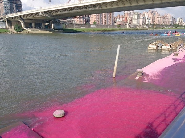 「The Color Run」活動結束隔天，有民眾拍到基隆河被彩粉染紅的畫面。圖：Alice Chen/攝   