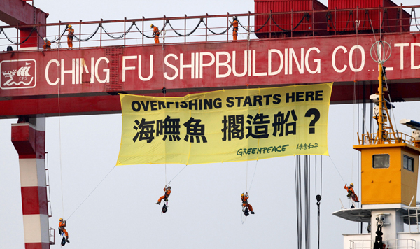 綠色和平組織「希望號」工作人員攀爬天車吊桿，掛巨幅布條抗議，過程驚險萬狀。來源：綠色和平組織   
