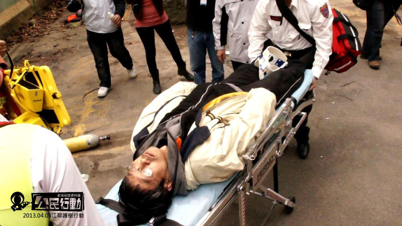 潘翰疆離開樹幹後，躺在擔架上，被警消送往板橋縣立醫院診治。圖片來源：翻攝江翠護樹志工隊臉書   