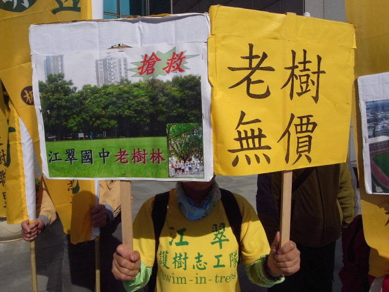 居民高舉標語，誓言要捍衛家園旁邊的200棵老樹。圖片：楊宗興攝   