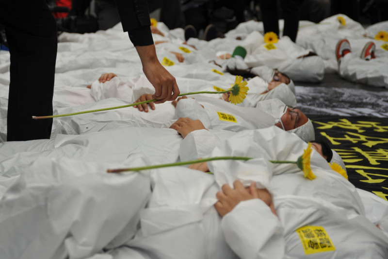記者會的最後，由2名手持黃色鮮花的黑衣人，一一將手中的花朵放在躺在地上的人身上，代表對核災受害者的哀悼，也象徵不希望台灣出現一樣恐怖的場景。圖：楊宗興/攝   